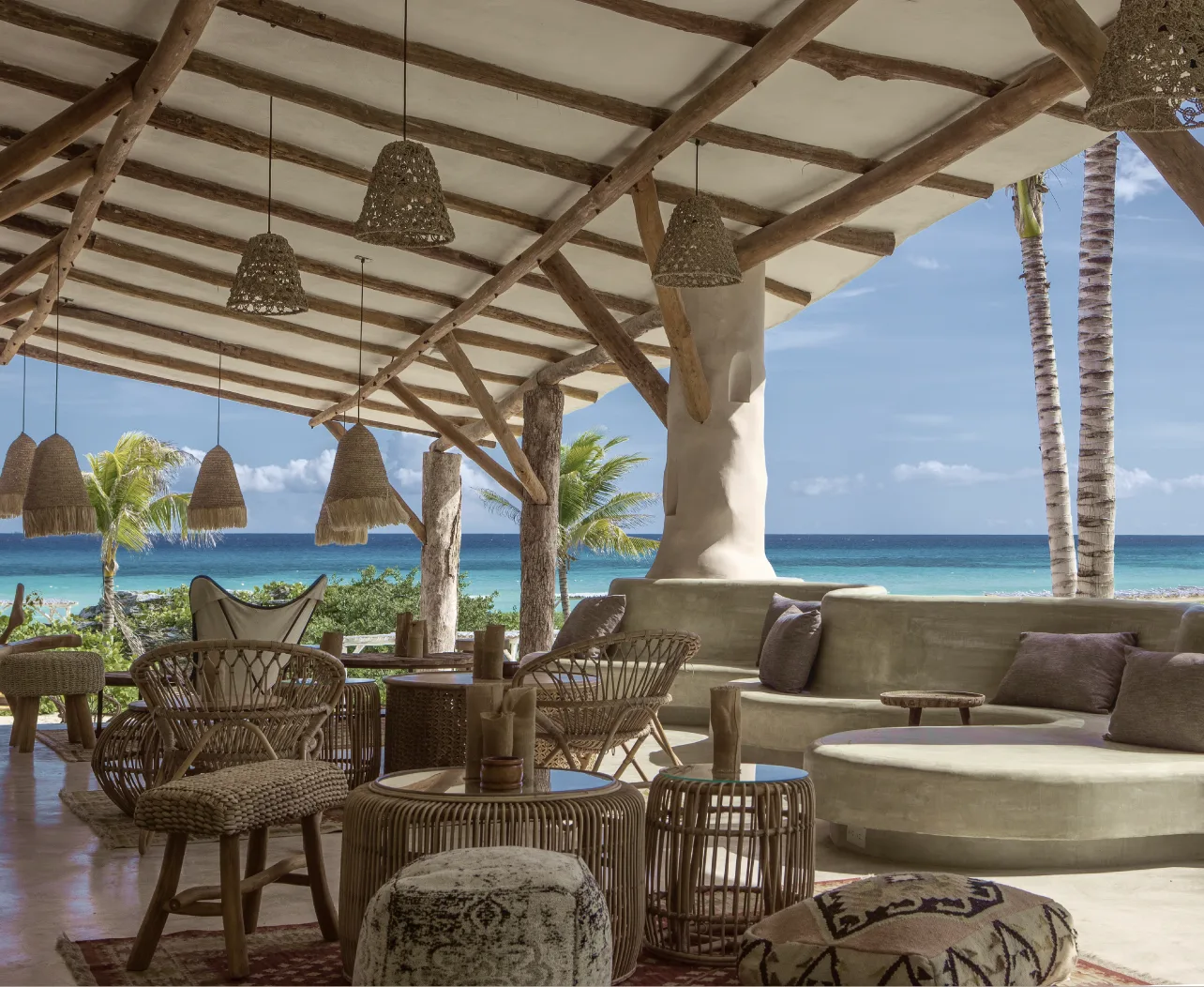 Open-air lounge with woven pendant lights overlooking the sea